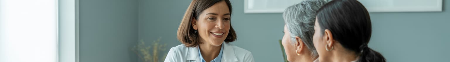 Hispanic doctor consulting with Spanish-speaking patient and bilingual daughter using AI-powered multilingual clinical documentation in modern medical office